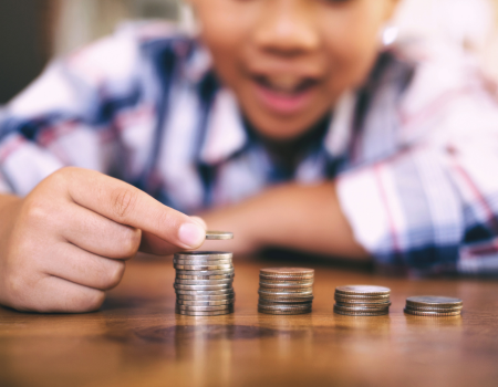 A boy placing a coin on a stack